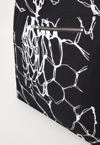 Tessuto nero con stampa floreale astratta bianca e una tasca con zip orizzontale in argento.