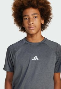 Gray athletic t-shirt made of soft fabric, featuring a round neckline and short sleeves, with a white Adidas logo on the chest.