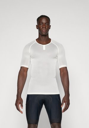 T-shirt de sport à manches courtes en mesh blanc avec un col rond et un petit bouton à l'avant, associé à un short sombre ajusté. Texture lisse.