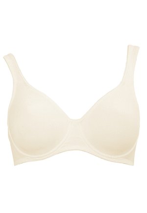 Beige wireless bra with smooth, stretchy fabric. Features soft cups and adjustable straps. Seamless design for a streamlined appearance.