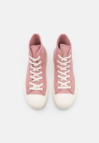 Högkanta sneakers i mjuk rosa ribbad textil med vit gummitå och snören, med en vadderad krage för komfort.