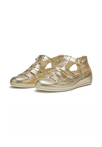 Chaussures plates métalliques dorées avec un design tissé, des côtés ouverts, une bride de cheville réglable et un bout arrondi. Texture lisse et semelle flexible.