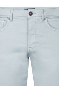 Pantaloni in denim azzurro chiaro con chiusura anteriore a zip e bottone, due tasche frontali e cuciture decorative lungo le cuciture.
