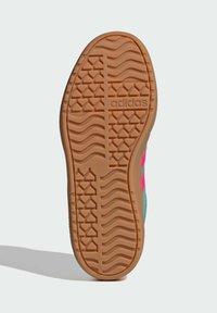 Suola in gomma con un motivo testurizzato e scanalature, caratterizzata da una striscia rosa e dal logo "adidas" impresso. La combinazione di colori include gomma e teal.