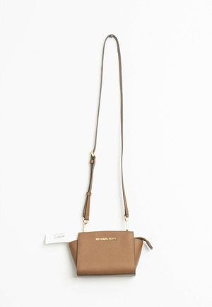 Mała brązowa skórzana torebka na ramię Michael Kors z długim regulowanym paskiem i złotymi elementami na białym tle.