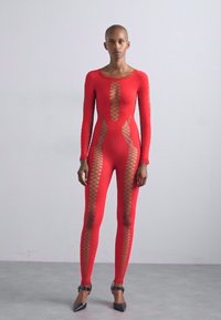 Body roșu cu un design ajustat, mâneci lungi și decupaje mari din plasă pe laterale. Textură netedă, cusături minime, purtat cu tocuri ascuțite.