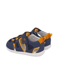 Sandalias infantiles de color azul marino con acentos amarillos, fabricadas en material suave. Cuentan con paneles de malla y una correa de gancho y bucle para un fácil ajuste.
