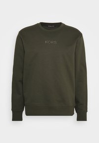 Felpa verde oliva scuro con collo a giro e polsini a coste. Sul davanti è ricamato "KORS" in una tonalità più chiara.