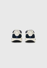 Navy and cream sneakers with a suede texture, padded collar, and rear pull tab. "NEW HAVEN" embossed on the back. Chunky rubber sole.