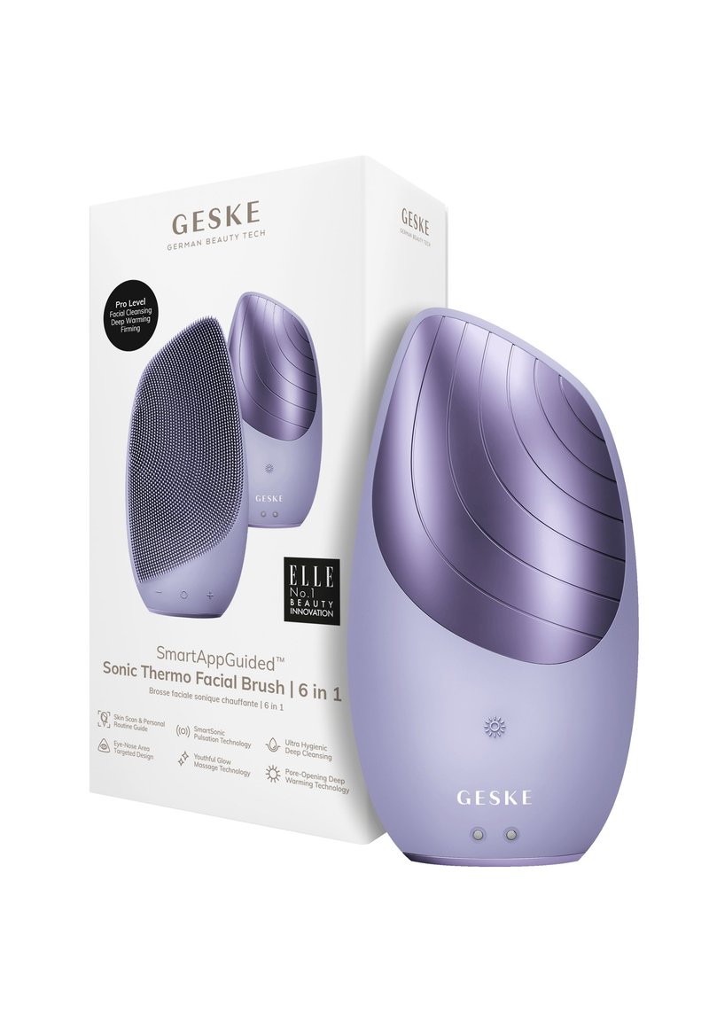 Spazzola facciale sonica in silicone viola con superficie di pulizia texturizzata e curve lisce. Imballata in una scatola bianca con i dettagli del prodotto esposti.