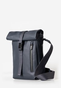 Dunkelgraue Roll-Top-Schultertasche mit vertikalem Reißverschlussfach an der Vorderseite, verstellbarem Strap und Plastik-Schnellverschluss auf weißem Hintergrund.