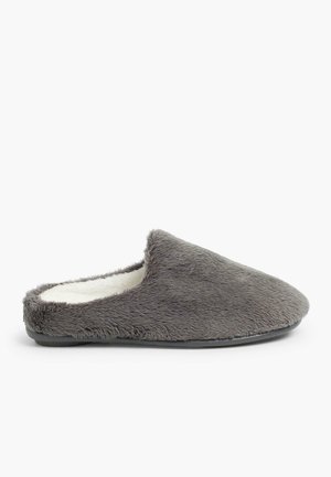 Zapatilla de casa gris forrada de piel sintética con un diseño de puntera redondeada y suela negra plana. Textura suave con una apariencia esponjosa.