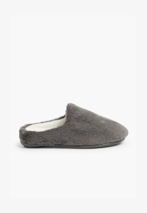 Zapatilla de casa gris forrada de piel sintética con un diseño de puntera redondeada y suela negra plana. Textura suave con una apariencia esponjosa.