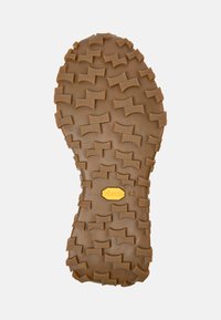 Suola in gomma con scanalature profonde e angolari di colore tan, con logo Vibram e numero 42, progettata per la trazione e la durata.