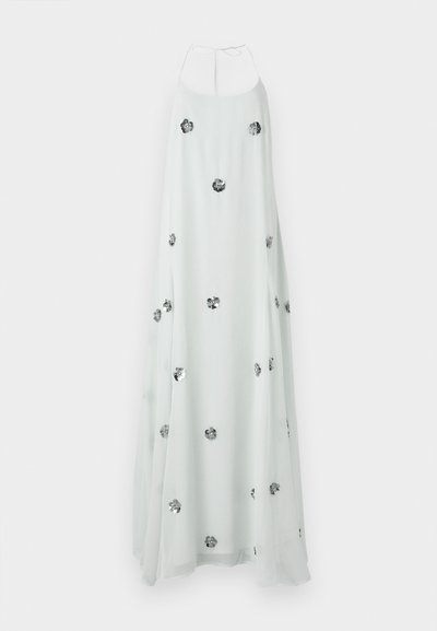 Vestido maxi blanco con cuello halter, adornado con detalles de flores plateadas por todo el vestido. Su tejido fluido y ligero crea una textura suave.