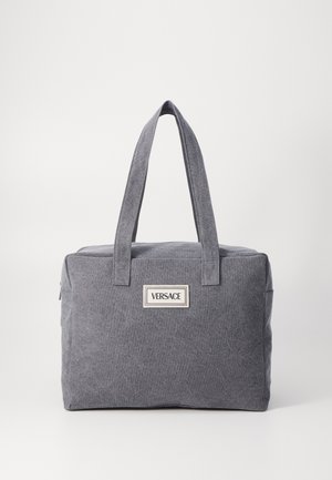 Szürke vászontáska, két erős fogantyúval, cipzáras zárással és egy kiemelkedő logóval az elején. Téglalap alakú, texturált felülettel.