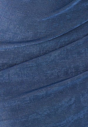 Denim w głębokim niebieskim kolorze z subtelnymi diagonalnymi paskami i gładką fakturą, prezentujący warstwowy, płynny design.
