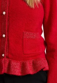Rode gebreide cardi met een gestructureerde weving, parelknoopjes, een voorknoopzak en een gerimpelde zoom met een metallic draadaccent.