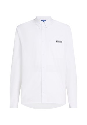 Valge pika varrukaga nööpidega särk taskuga, millel on rinnal must logo plaastriga, valmistatud siledast puuvillakangast.