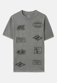 Halli puuvillane t-särk, millel on mitmeid reljeefseid patse, millel on erinevates kujudes ja suurustes "Armani Exchange" bränding. Ümmargune kaelus.