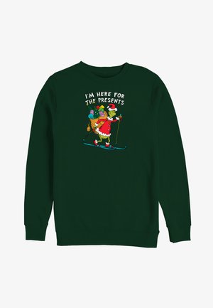 Sudadera verde con un gráfico del Grinch vestido de Santa esquiando con una bolsa de regalos, el texto dice "ESTOY AQUÍ POR LOS REGALOS."