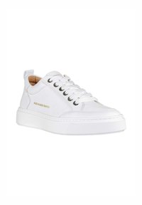Sneakers bianchi in pelle con finitura testurizzata, punta rotonda e suola piatta in gomma bianca. Presentano un logo dorato e occhielli in argento per i lacci.