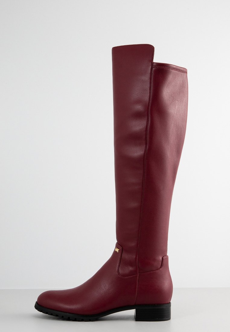 Stivali in pelle bordeaux fino al ginocchio con una texture liscia, forma rettangolare, tacco basso nero e un delicato dettaglio di branding sul lato.