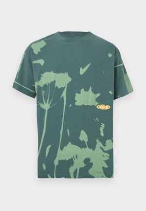 Green tie-dye short-sleeve Nike t-shirt with light green floral patterns and Nike swoosh logo on the chest.
