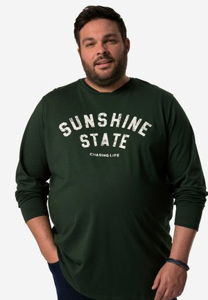 Groene longsleeve T-shirt van katoen, met de tekst "SUNSHINE STATE" in witte versleten letters over de borst. Casual pasvorm.