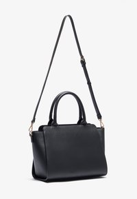 Svart läderhandväska med dubbla handtag och en justerbar axelrem. Slät textur och strukturerad design, med detaljer i guldton.