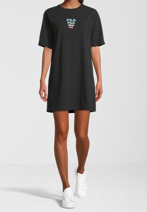Vestito a t-shirt corto a maniche corte nero in cotone, con logo "FILA" multicolore sul petto, abbinato a sneakers bianche.