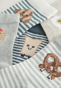 Barevné ponožky s potisky inspirovanými jídlem: chléb, preclík, muffin a vejce. Texturovaná pletenina s různými vzory a pastelovými barvami.
