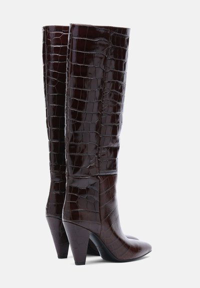 Bottes marron foncé montantes avec un motif crocodile brillant et des talons blocs hauts et inclinés.
