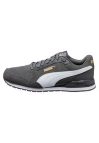 Baskets Puma gris foncé avec bande blanche latérale, semelle noire et logo Puma doré sur le côté et le talon, vues de l'extérieur.