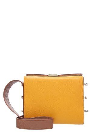 Gele textuurige schoudertas met bruine verstelbare band en zilveren sluiting, weergegeven tegen een witte achtergrond.