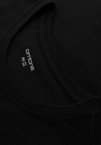 Černé bavlněné tričko s kulatým výstřihem a šitým zakončením. Obsahuje štítek s textem "ombre" a informacemi o velikosti v bílé barvě.