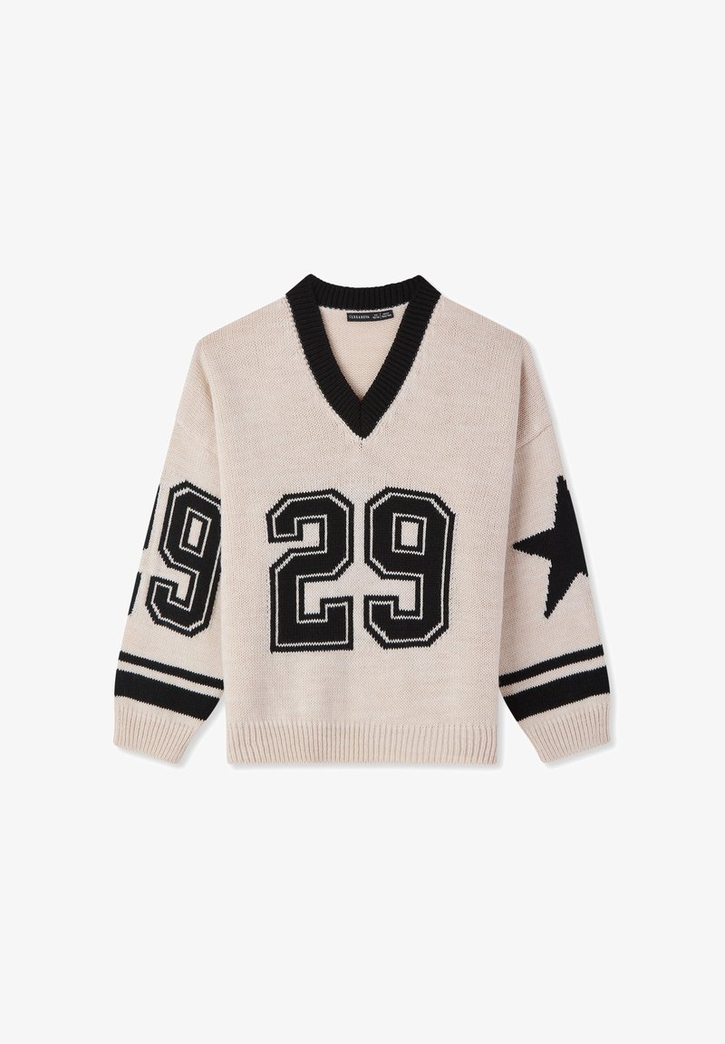Maglione lavorato a maglia color crema con scollo a V nero. Presenta un grande "29" nero sul davanti, motivo a stelle sulla manica e polsini a righe. Finitura strutturata.