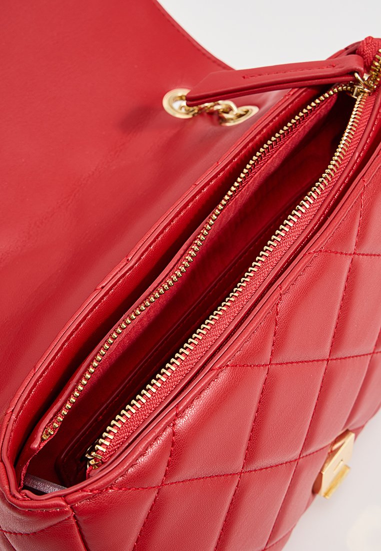 Rote gesteppten Lederhandtasche mit glatter Oberfläche, ausgestattet mit goldenen Beschlägen und einem Reißverschlussfach für sicheren Verschluss.