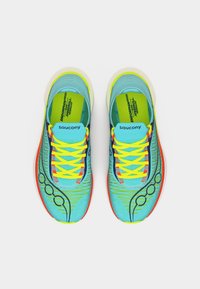 Φωτεινά μπλε και νέον κίτρινα παπούτσια τρεξίματος Saucony με πορτοκαλί λεπτομέρειες και διακοσμητικά σχέδια, σε προβολή από πάνω σε λευκό φόντο.