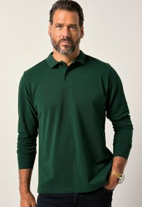 Polo de manga larga en verde oscuro con cuello, que presenta una tapeta de tres botones. El material parece suave con una textura sutil.