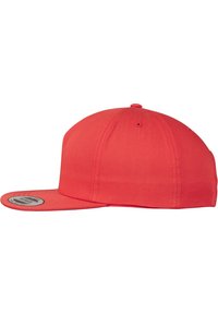 Rode snapback pet met een platte rand, gemaakt van katoenmateriaal, met een ronde logopatch aan de voorkant en zichtbare stikdetails.
