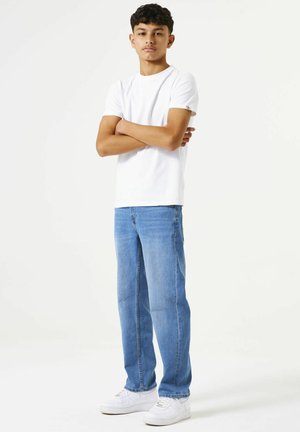 Wit t-shirt met korte mouwen, blauwe rechtvallende jeans en witte sneakers. De outfit heeft een casual pasvorm en een eenvoudig ontwerp zonder patronen.