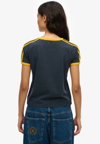 Navy blue t-shirt with yellow accents on shoulders and sleeves, featuring a crew neck and a relaxed fit, made from soft cotton blend material.