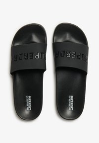 Infradito neri con suola in gomma testurizzata, dotati di una fascia larga con la scritta "SUPERDRY" in un finish lucido a contrasto.