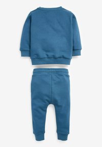 Blaues Sweatshirt und passendes Sweatpants-Set. Weicher Stoff, gerippte Bündchen, lockere Passform und elastischer Bund, minimalistische Details.