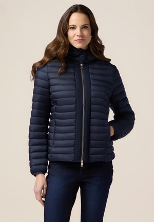 Veste rembourrée marine avec un design à boudins horizontaux, col montant, fermeture éclair et poignets côtelés. Matériau léger avec une texture lisse.