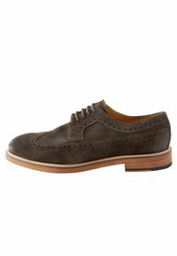 Dunkelbraune Suede-Brogue-Schuhe mit perforierten Details, Schnürdesign und einer kontrastierenden tan- und schwarzen Sohle.