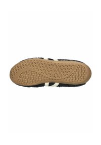 Sole di scarpa nera con texture e un motivo geometrico, caratterizzata da una base in gomma e strisce bianche. Progettata per durabilità e trazione.