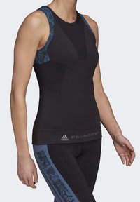 Černé atletické tílko s modrými vzorovanými ramínky, přiléhavý střih a textové logo na lemu. Materiál působí hladce a pružně.