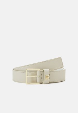Ceinture en cuir beige clair avec boucle rectangulaire dorée et bords cousus, présentant un logo doré "TH" sur la boucle de ceinture.